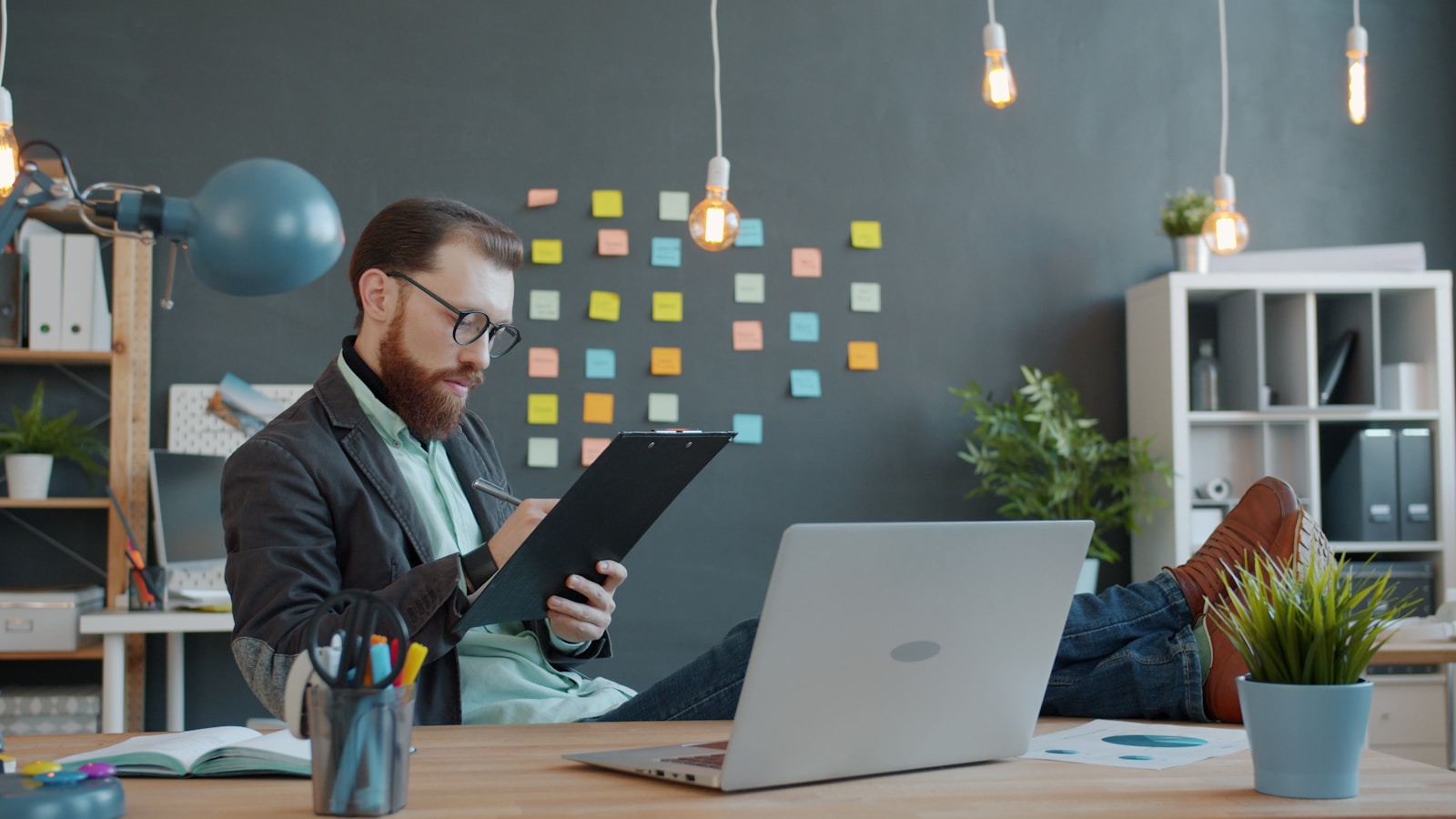 Man working at desk with laptop and notes